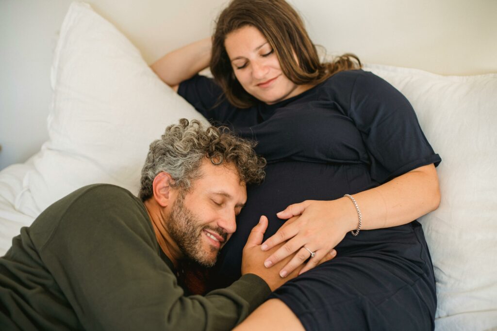 Un homme pose sa tête sur le ventre de sa femme enceinte