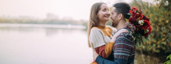 Couple joyeux, la jeune femme tient un bouquet de fleurs à la main