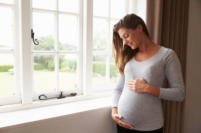 Une femme enceinte regarde son ventre