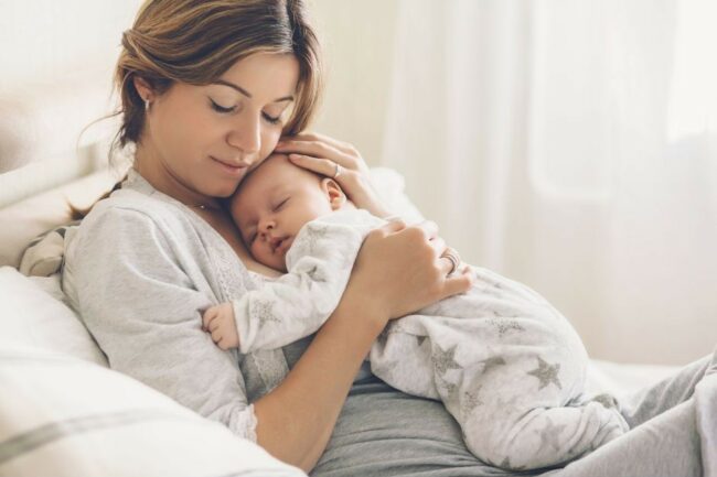 Une femme tient son nouveau-né contre elle